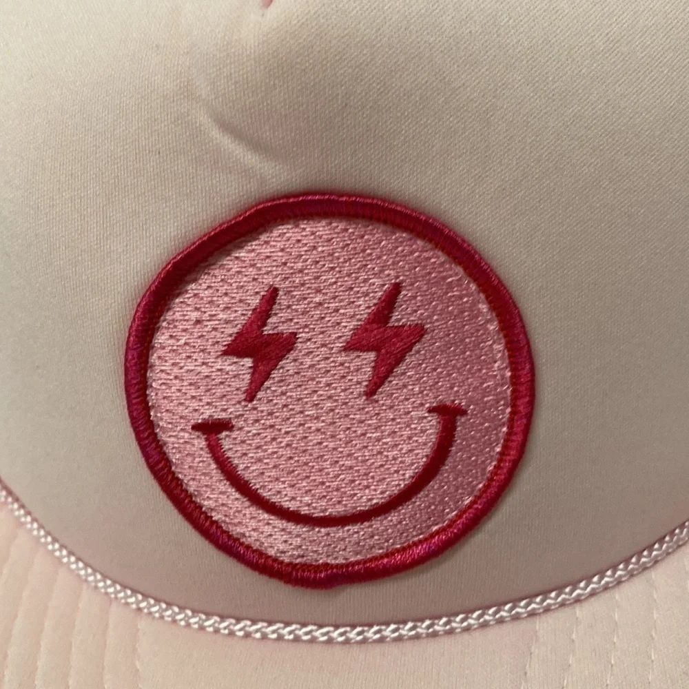 Lightning bolt smiley face trucker hat pink